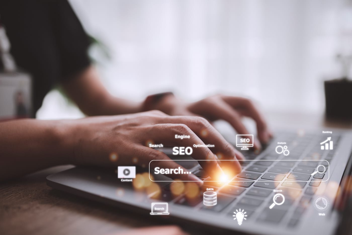 Mains tapant sur un clavier d'ordinateur portable avec des icônes lumineuses de SEO, recherche et analyse web